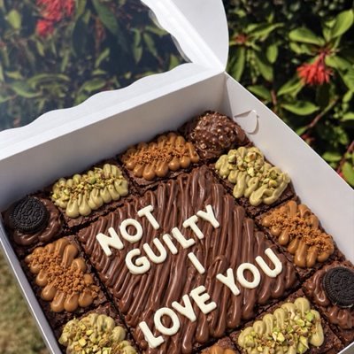 Brownie box with a piped message surrounded by mini toppings